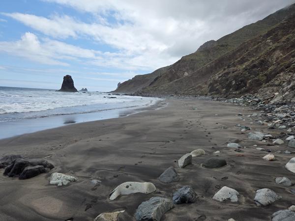Coastal view of Playa de Benijo with cliffs descending into the sea and black sand beach below.