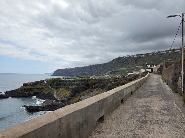 Concrete coastal lane with sweeping ocean views guiding visitors towards Playa El Bollullo.