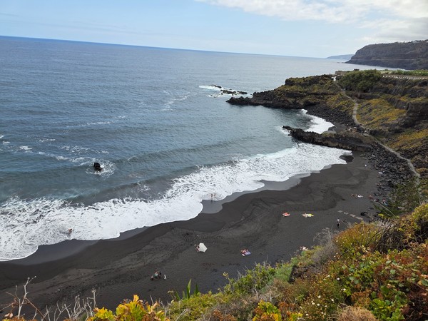 Sweeping aerial view of Playa El Bollullo and its horseshoe-shaped bay framed by volcanic cliffs.