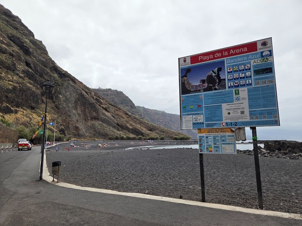 Information board at Playa de la Arena in Tacoronte showing the Blue Flag, a map of the cove, and safety guidelines for bathers.