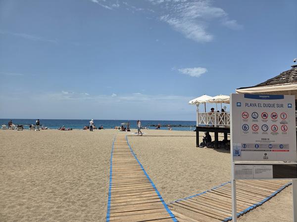 Entrance sign at Playa El Duque Sur with beach guidelines.
