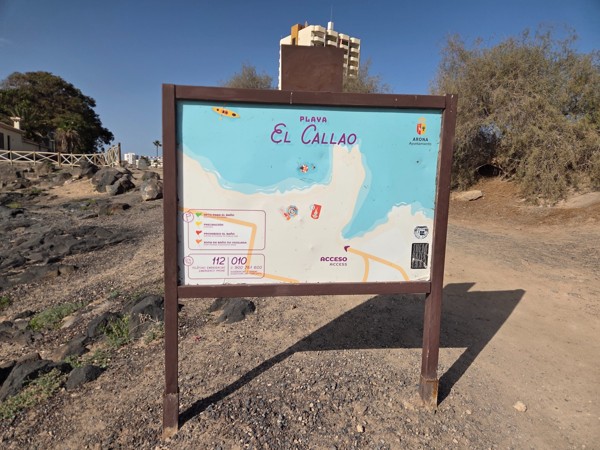 Information board of Playa El Callao on a dirt path in Arona, showing a map of the bay and safety recommendations for visitors.