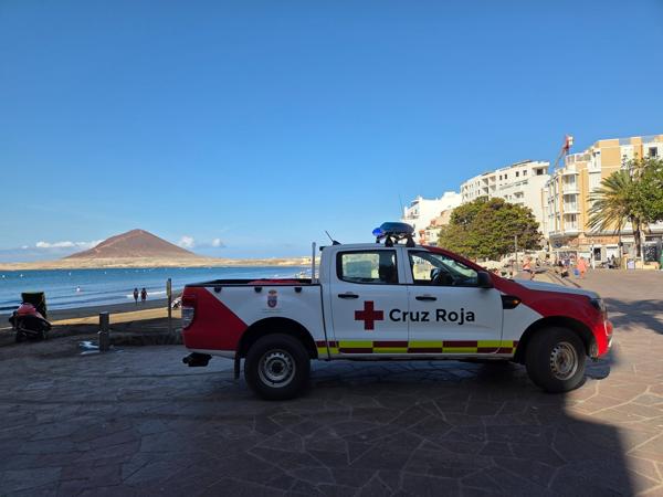 Red Cross vehicle parked near Playa El Médano with Montaña Roja visible in the distance.