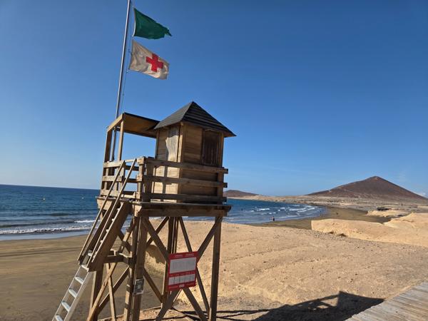Lifeguard tower with flags overlooking the beach and ocean at Playa El Médano.