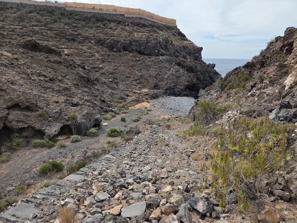Rocky descent (bajada) through a ravine toward Playa de Ricasa on Tenerife’s southwest coast.