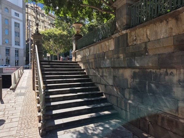 Stone staircase with metal railings leading up to the elevated plaza in Santa Cruz.