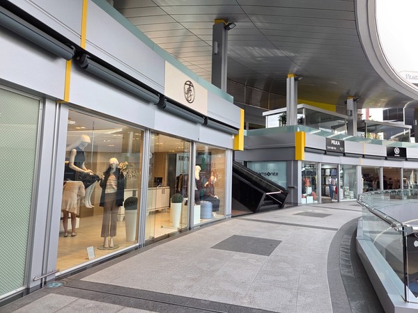 Elegant gallery with escalator access and fashion stores, giving an easy flow between levels.