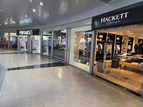 Hackett London boutique interior with folded knitwear and travel items.