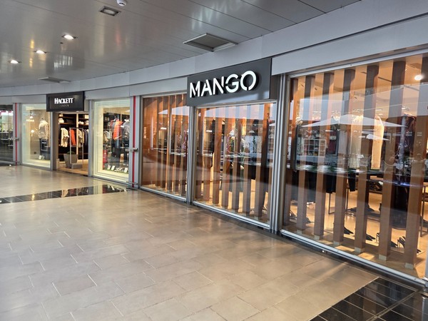 Wide Mango storefront along an interior gallery at Plaza del Duque.