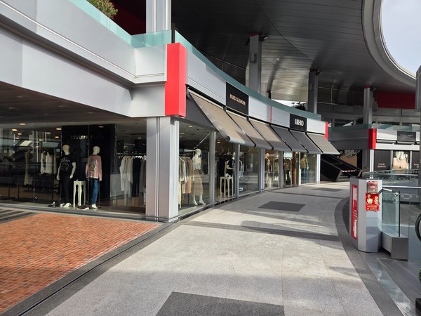 Row of upscale boutiques like Plaza Glamour and LIU•JO on a curve of the upper level.