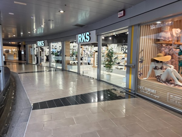 RKS multi-brand shoe store stretching along a wide interior corridor.