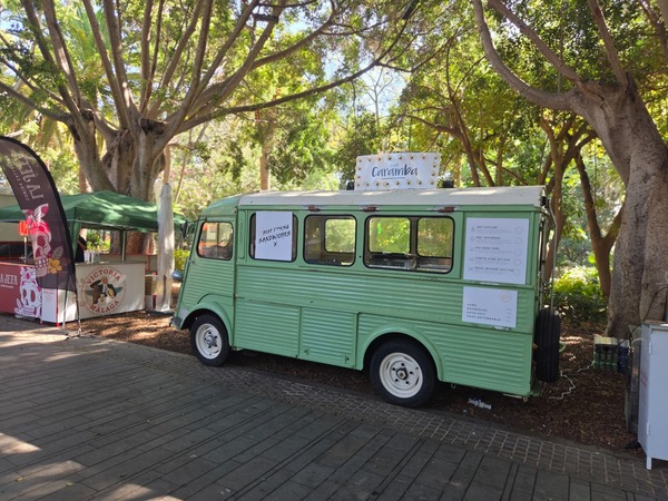 Café Caramba vintage food truck serving specialty coffee and toasties in the shade. Taken at Plenilunio 2025 in García Sanabria Park, Santa Cruz de Tenerife.