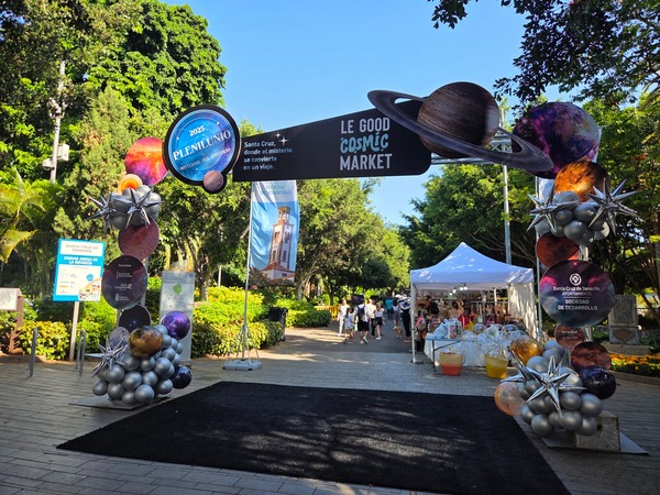 Gate for Le Good Cosmic Market decorated with planets and silver balloons. Taken at Plenilunio 2025 in García Sanabria Park, Santa Cruz de Tenerife.