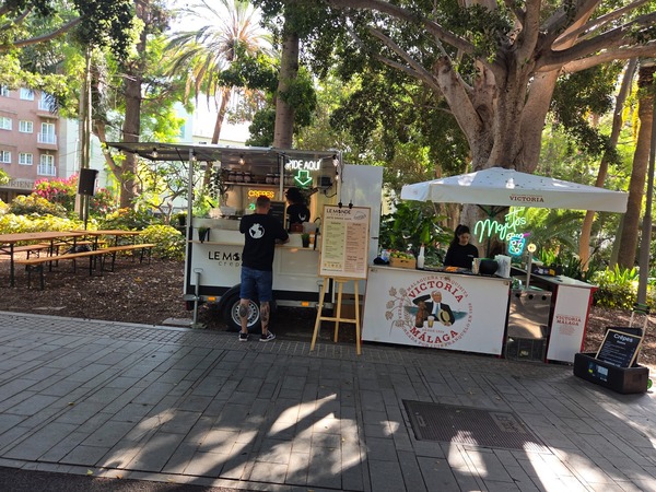 Crepes kiosk next to a mojitos bar with picnic tables nearby. Taken at Plenilunio 2025 in García Sanabria Park, Santa Cruz de Tenerife.