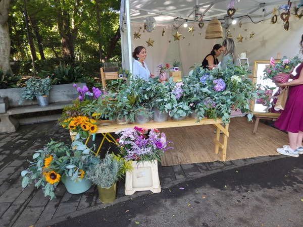Florist stall full of sunflowers, eucalyptus and hydrangeas in rustic buckets. Taken at Plenilunio 2025 in García Sanabria Park, Santa Cruz de Tenerife.