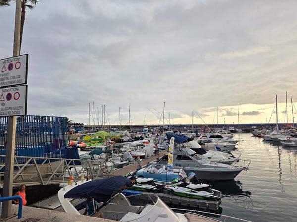 Numerous boats and yachts docked at Puerto Colón marina under cloudy skies