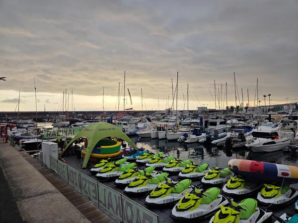 Jet skis arranged in rows on floating docks ready for rental at Puerto Colón