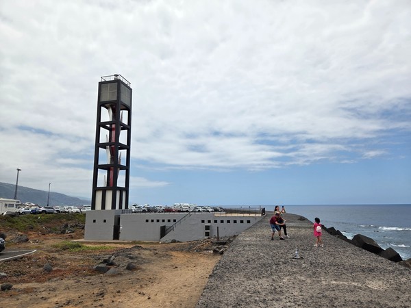 Modern beacon tower by the breakwater with the Atlantic in the background at Puerto de la Cruz.