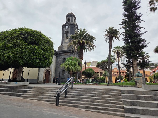 Main parish church with clock tower and palm trees on the square in Puerto de la Cruz.
