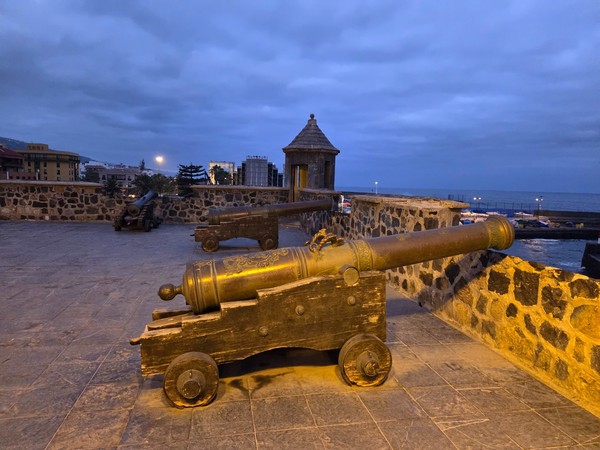 Historic bronze cannons on the ramparts of Castillo San Felipe at dusk in Puerto de la Cruz.