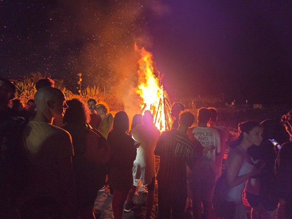 Crowds around a blazing San Juan beach bonfire at night in Puerto de la Cruz.