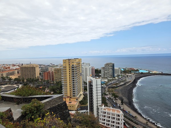 Panoramic view over Puerto de la Cruz with high-rises, the coast, Lago Martiánez and the Atlantic Ocean.