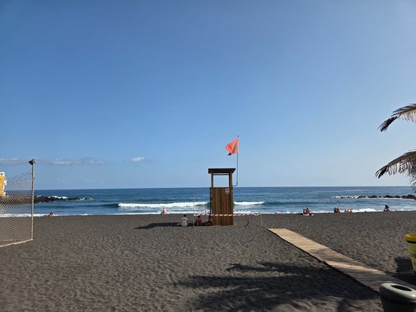 Lifeguard tower with a red warning flag on Punta Brava Beach.