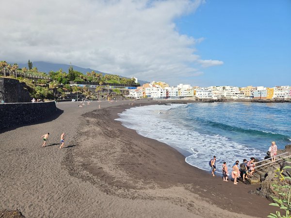 Wide view of Punta Brava Beach with black sand and colourful houses in Puerto de la Cruz.