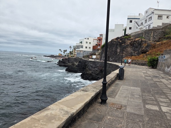 Seafront promenade and natural pool area with bathers in Punta del Hidalgo.