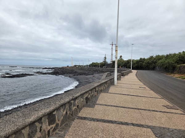 Paved coastal walk at Punta del Hidalgo with the lighthouse in the distance.