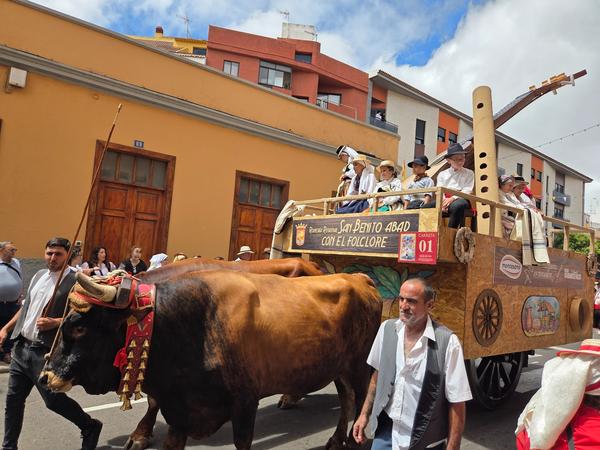 Cart labeled San Benito Abad with children dressed in traditional costumes.