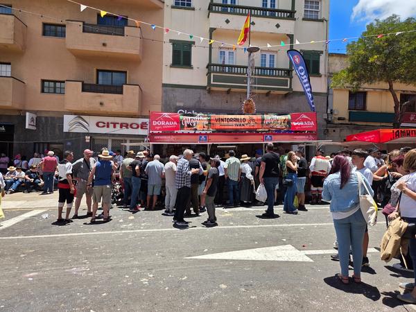 Crowds enjoying drinks and food at traditional Canarian kiosks.