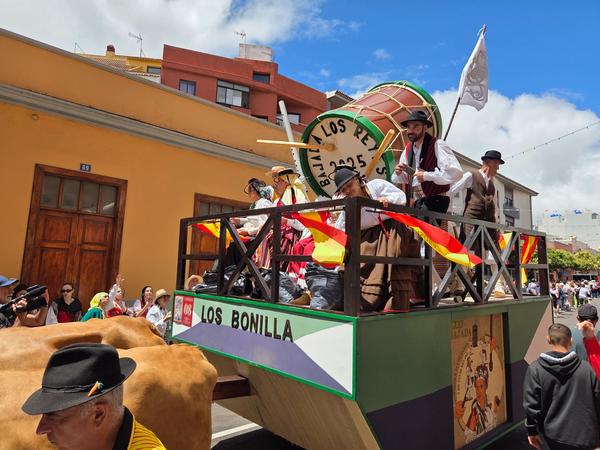 Ox cart Los Bonilla with participants in folk costumes and a giant barrel prop.
