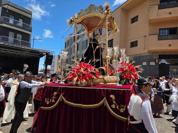 Elaborate float of Saint Benedict surrounded by flowers and offerings.