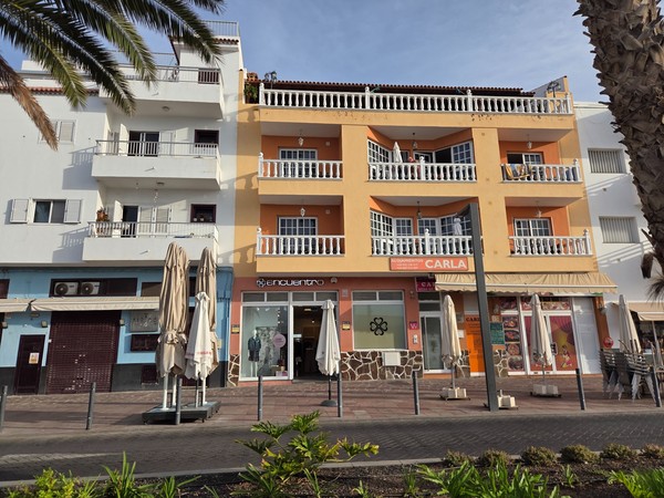 Façade of shops and apartments along the main seafront avenue in Playa San Juan.
