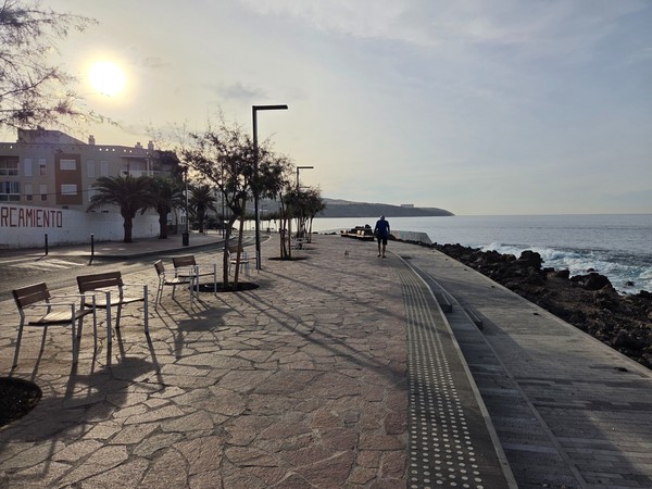 Red surfaced coastal path in Playa San Juan with interpretive marine panel and Atlantic views.