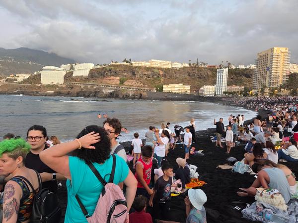People wading and swimming in the ocean at dusk as part of the San Juan cleansing ritual.