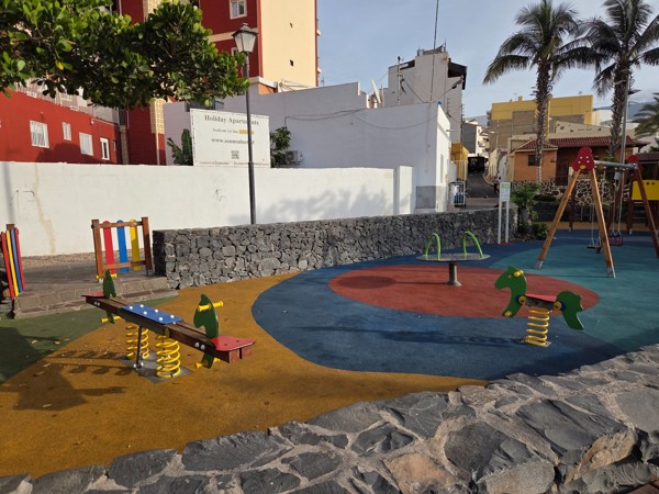 Children’s playground in Playa San Juan with spring riders, swings and soft flooring.