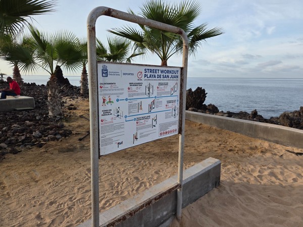 Instruction sign for the street workout area at Playa de San Juan outlining exercises.