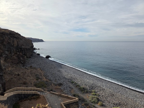 Lonely stretch of pebble shore with gentle waves south of Playa San Juan.
