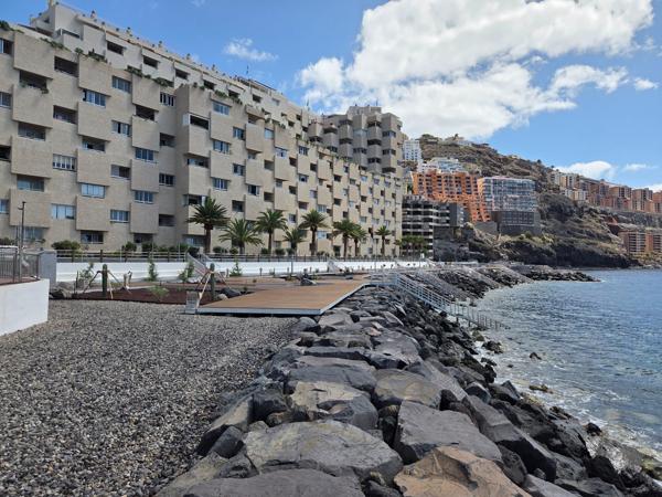 Dark volcanic rocks and wooden stairs to a cove