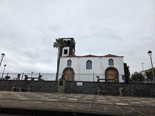 Historic parish church with a dark volcanic-stone bell tower in Tacoronte, Tenerife.