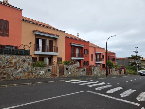 Modern terraced homes with stone walls and balconies in a Tacoronte neighborhood.