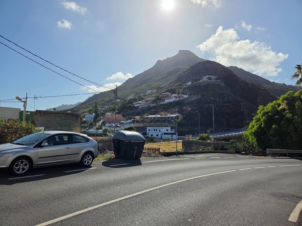 Roadside view toward the rocky hills and antennas that rise above Tejina.