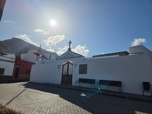 Entrance gate of the Cementerio Municipal de Tejina with cross and white walls.