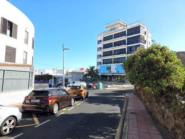 Modern apartment building with reflective windows on a quiet street in Tejina.