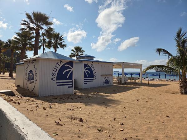 The Agüita Salada kiosk welcomes beachgoers with its tropical design and shaded seating near the entrance of Las Teresitas.