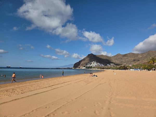 An early morning view of Playa de Las Teresitas reveals calm waters and soft golden sand perfect for a relaxing beach day.