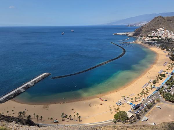 The elevated view reveals the smooth gradient from shallow turquoise to deep ocean blue, protected by breakwaters.